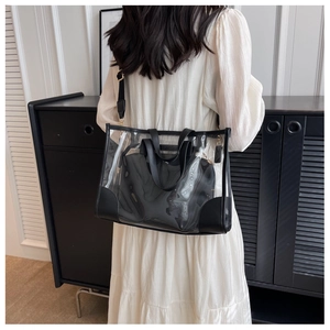 Detailed shot of transparent PVC tote bag with black inner pouch on fashion model