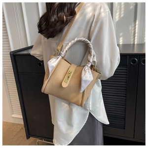 Detail of lychee pattern leather bucket bag with silk scarf handle and gold metal lock