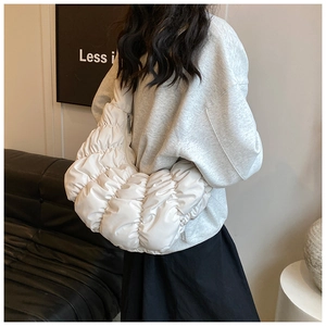 Weiße Croissant-Schultertasche mit Falten-Design und Halbmondform an einem Model