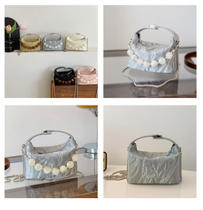 Detail van een geplooide mini crossbody tas met grote parels en een zilveren ketting