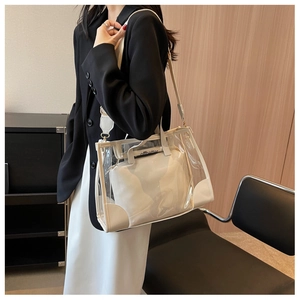 Close-up of transparent PVC tote bag with white leather trim and internal offbetter pouch