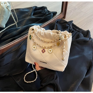 Détail du sac seau matelassé avec breloques colorées et chaîne en métal doré