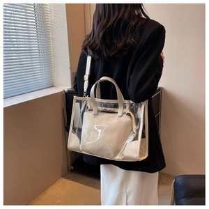 Detail of jelly tote set worn over shoulder featuring white leather trim and gold hardware