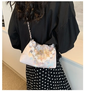 Détail du sac bandoulière en satin brodé avec poignée en perles et chaîne métallique
