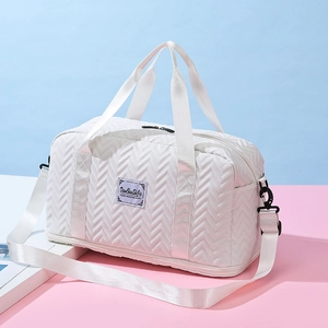 White large travel bag with V-quilted pattern and adjustable strap on bicolor background