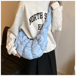 Detail der hellblauen gesteppten Croissant-Tasche mit Faltenstruktur und Puffy-Design