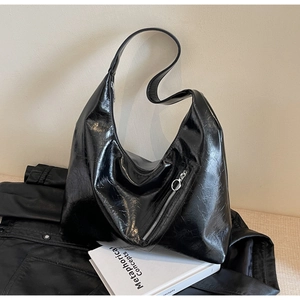 Macro shot of glossy black pleated leather Hobo bag with silver zipper detail