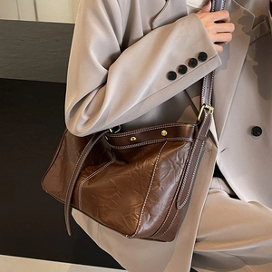 Vintage brown leather tote bag with white stitching and gold rivets for women