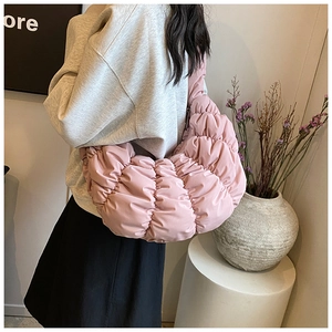 Lifestyle-Aufnahme der rosa gesteppten Croissant-Schultertasche am Model im Alltag