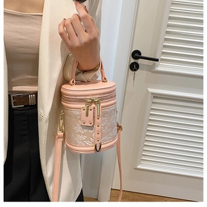 Pink bucket bag with white floral embroidery and dual-zipper closure detail