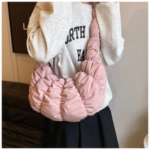 Tragefoto einer blassrosa gesteppten Hobo-Tasche mit modischer Knitter-Textur