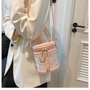 Detail of pink embroidered bucket bag with delicate floral lace and gold hardware