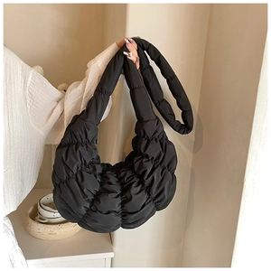 Detail der schwarzen Croissant-Tasche mit gestepptem Stoff und geraffter Textur