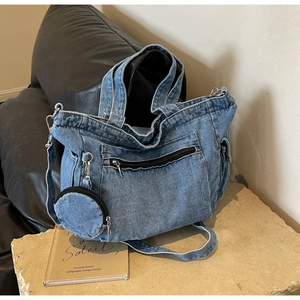 Blue washed denim tote bag with multiple zipper pockets and detachable coin purse accessory