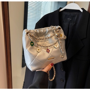 Détail du sac seau matelassé argenté avec chaîne dorée et breloques cœurs colorés