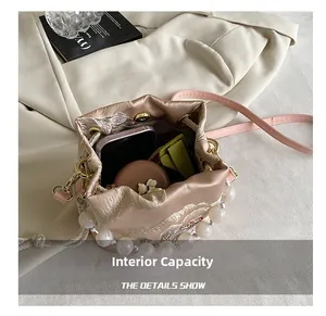 Detailed view of pink satin bucket bag interior showing capacity for makeup and cards