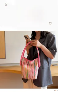 Detail einer rosa geflochtenen Tragetasche mit bunten Streifen und Ledergriffen