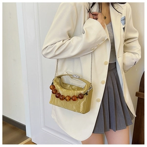 Modieuze gembergele geplooide crossbodytas met amberkleurige kralen en ketting