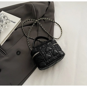 Detail of heart-quilted black leather mini box bag with gold-tone chain strap