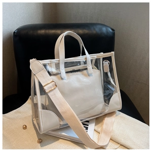 Detail view of transparent jelly tote with white trim and wide fabric shoulder strap