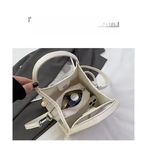 Vista interior del bolso tote con rayas de colores y gran espacio para cosméticos
