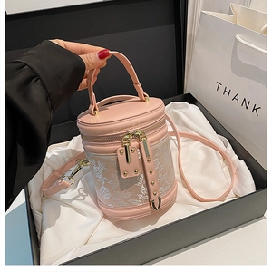 Detail of pink bucket bag with lace floral patchwork and gold stud hardware in a gift box