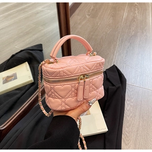 Detail of pink heart-quilted crossbody box bag with gold metal chain and dual zippers