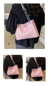 Details der rosa gefalteten PU-Ledertasche mit silberner Metallkette und Logo-Plakette