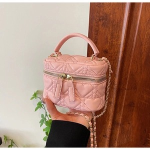Close-up of pink heart-quilted mini box bag with gold-tone chain and dual zippers