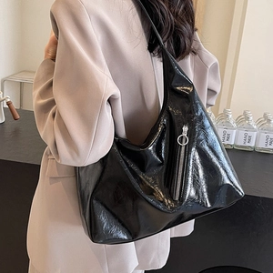 Large black patent leather hobo shoulder bag with glossy crinkle texture and metal ring zipper