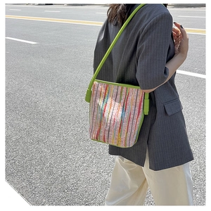 Photo style urbain d'un sac cabas à rayures colorées avec bandoulière en cuir vert vif