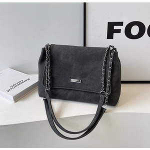 Detail der dunkelgrauen Klapptasche mit Kettenriemen und strukturiertem Stoff mit Logo