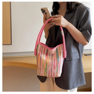 Détail du sac cabas tissé à rayures colorées avec anses roses et forme seau