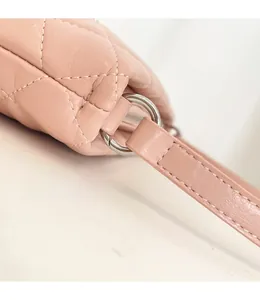 Close-up of premium stitching and silver metal hardware on pink quilted leather handbag