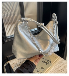 Close-up of silver pleated underarm bag with marble bead chain and metal strap detail
