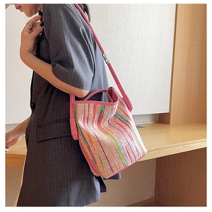 Détail du sac cabas tissé à rayures colorées avec bandoulières roses sur mannequin