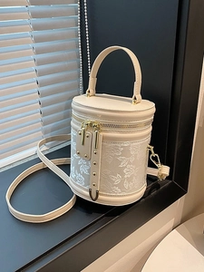 Elegant cream cylinder bucket bag with floral embroidery and gold hardware detail