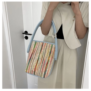Détails du sac cabas tissé à rayures colorées avec anses en cuir bleu clair et rivets