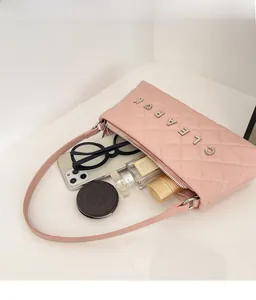 Pink quilted baguette bag showing internal space with phone, perfume, and sunglasses