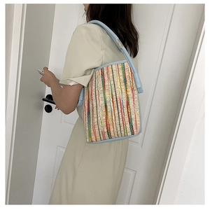 Détail du sac cabas tissé coloré avec sangle en cuir bleu clair et motif à rayures d'été