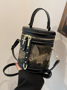 Elegant black leather bucket bag featuring gold butterfly embroidery and top handle