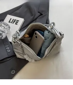 Interior view of silver metallic shoulder bag showing storage for phone and umbrella