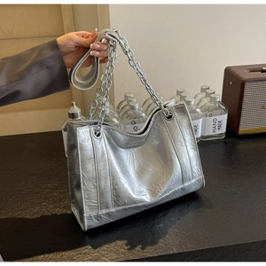 Nahaufnahme der silbernen Tragetasche mit Crinkle-Struktur, Kettengurt und Metallic-Finish