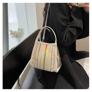 Detail der bunt gestreiften gewebten Tasche mit weißen Ledergriffen und beiger Textur