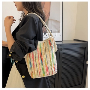 Detailansicht der Canvas-Eimertasche mit bunten Streifen und weißem Schultergurt-Design
