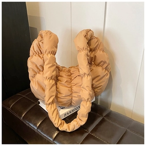 Detail der gesteppten beige Plissee-Tasche mit weicher, wolkenartiger Wattierung