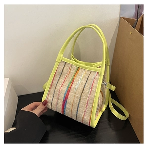 Gros plan d'un petit sac bandoulière tissé avec garniture jaune citron et rayures colorées