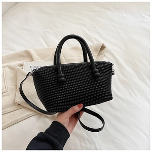 Détail du sac à main noir texturé avec anses rondes et bandoulière fine amovible