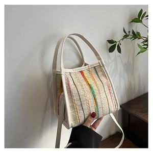 Detail der bunt gestreiften gewebten Handtasche mit cremefarbenem Lederbesatz