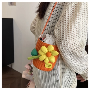 Detail of orange woven bucket bag with large 3D flower and drawstring inner lining